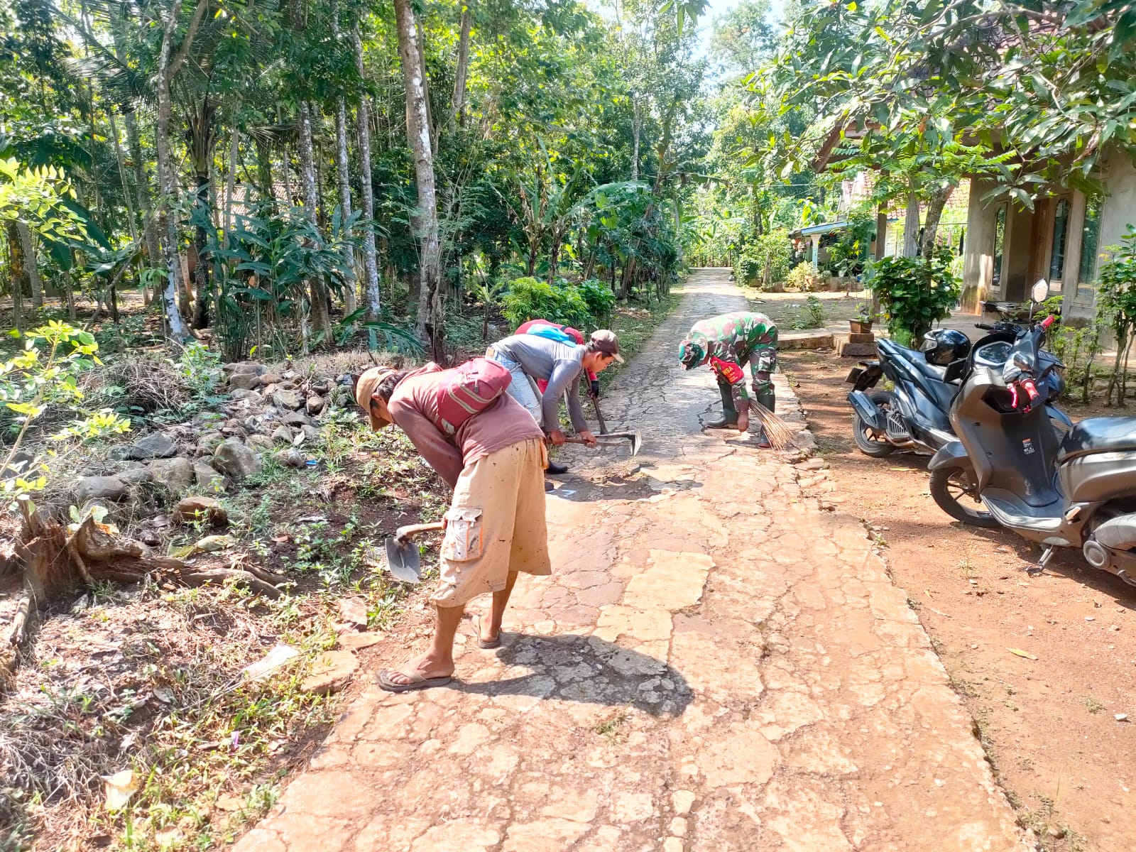 Babinsa Koramil 1507/Luragung bersama warga membersihkan jalan gang Desa Cileuya