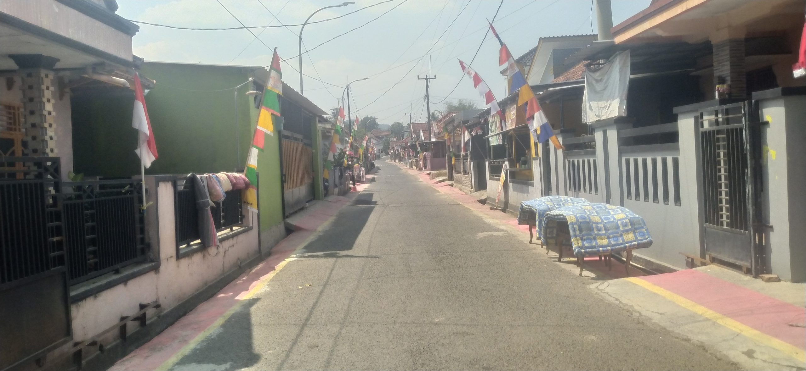 Jalan Desa Kananga Kecamatan Cimahi Kabupaten Kuningan dengan sisi jalan berwarna merah hasil penataan lingkungan desa