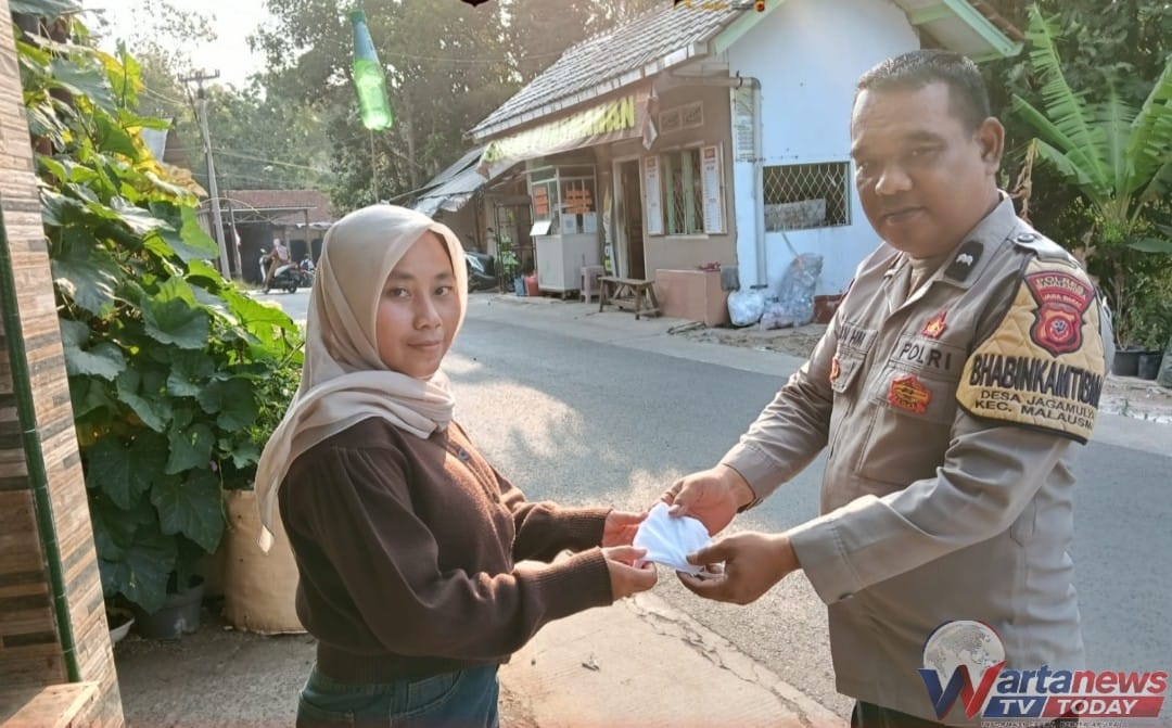 Bhabinkamtibmas Polsek Malausma membagikan masker kepada warga untuk antisipasi dampak abu vulkanik