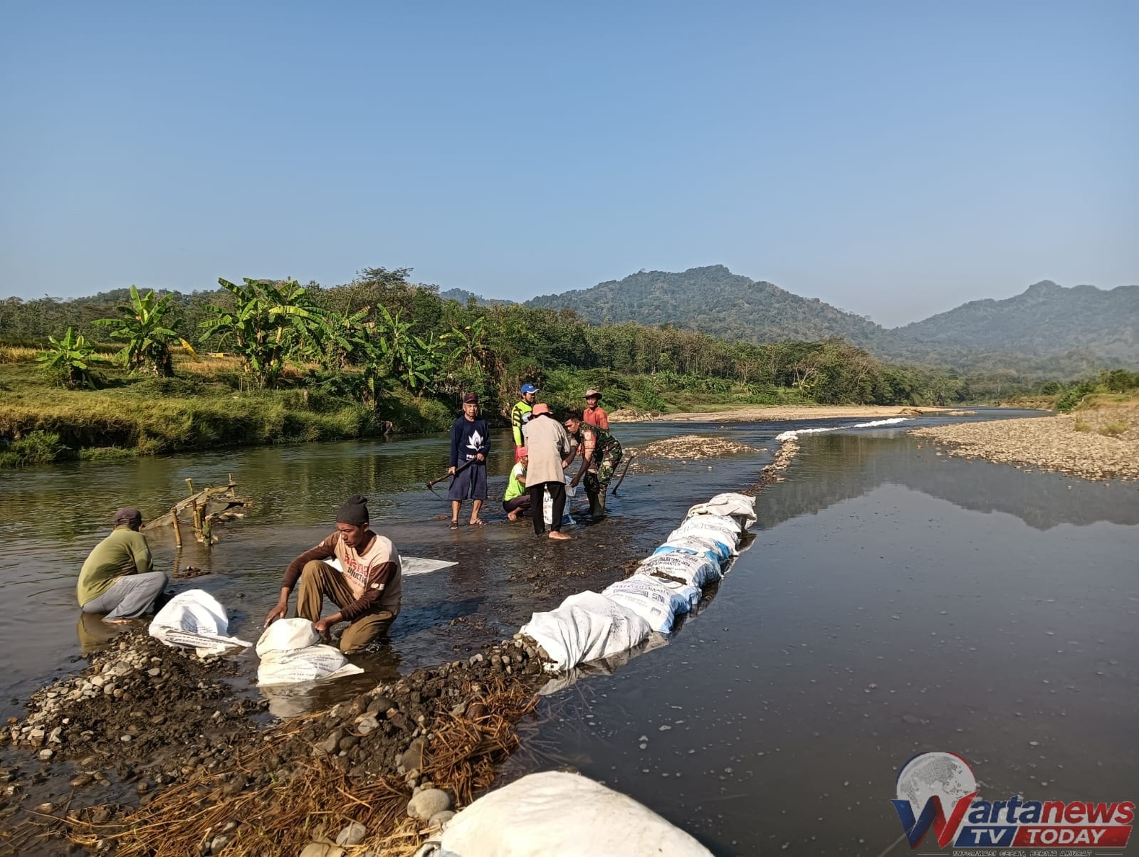 Babinsa dan warga Desa Dukuhpicung bergotong royong memperkuat bendungan Sungai Cisanggarung