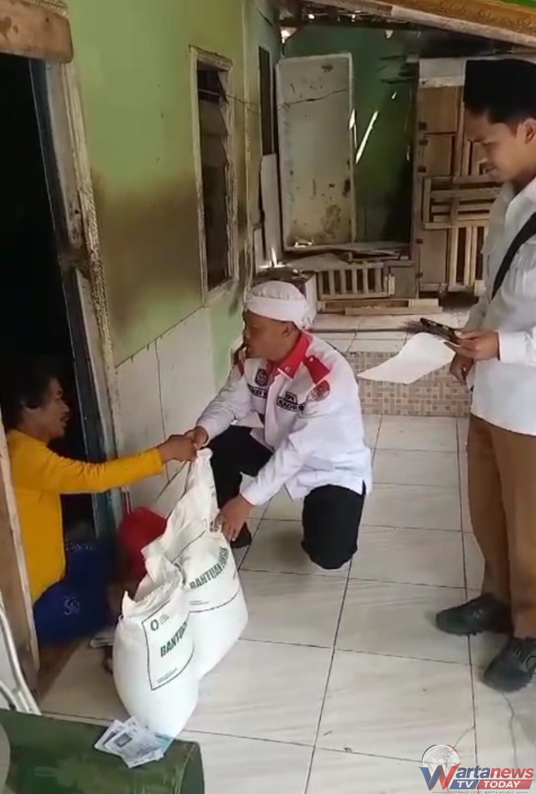 Kades Cigarugak E Dodi Nur menyalurkan bantuan beras kepada warga